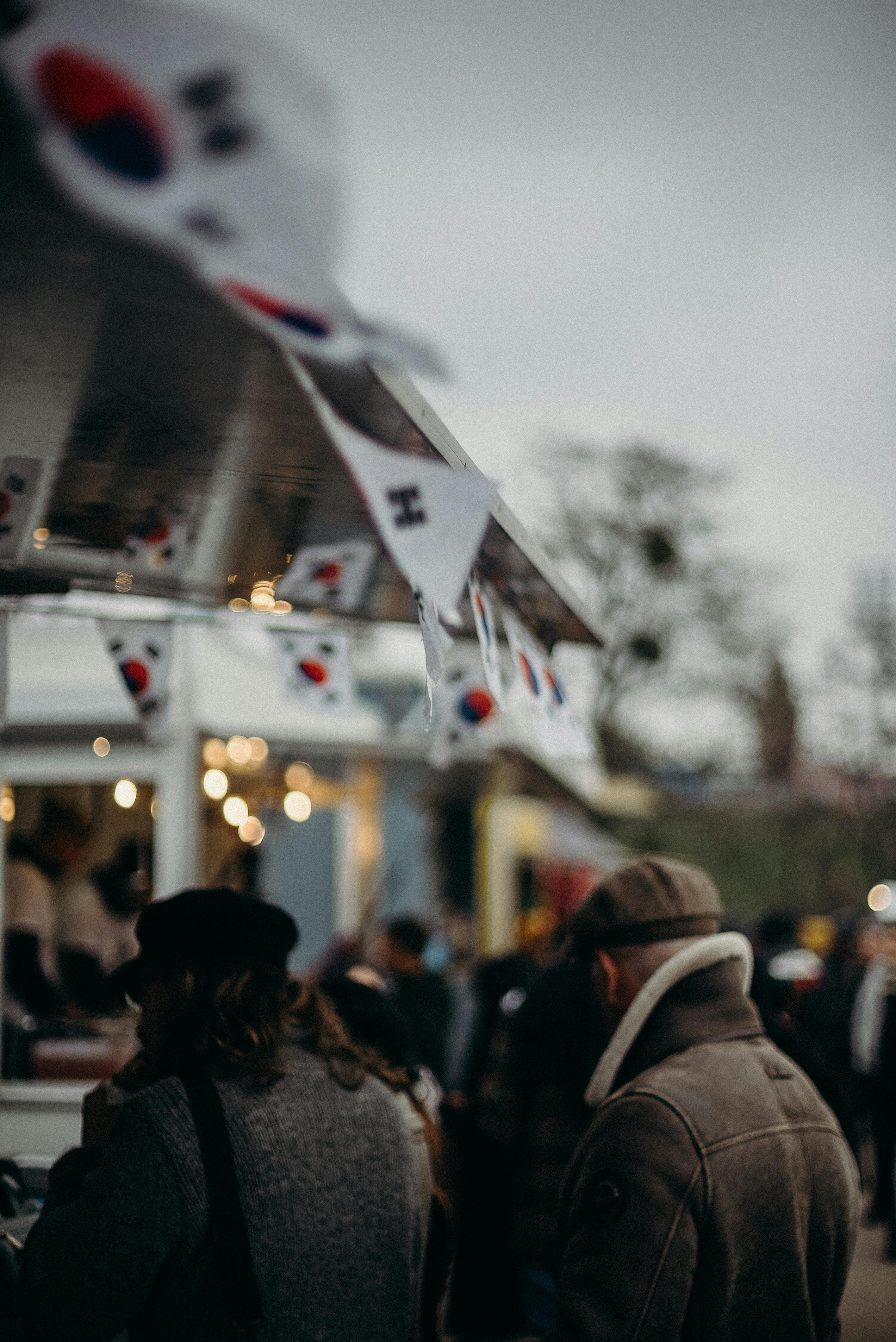 korean flags on a blurred background image of a house. People in the forground are blurred also